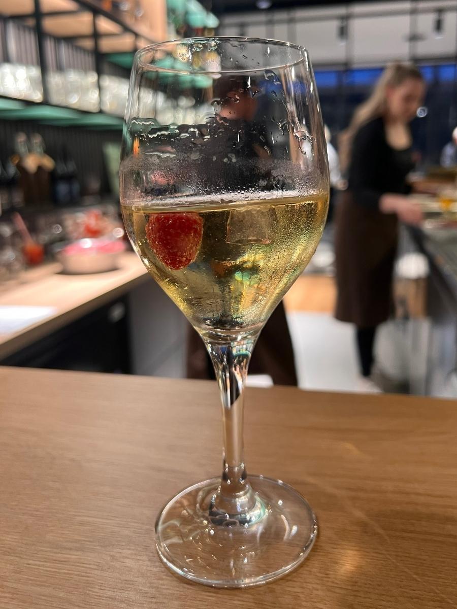Ein gekühltes Weinglas mit einer Beere vor der Bar im Waidmanns