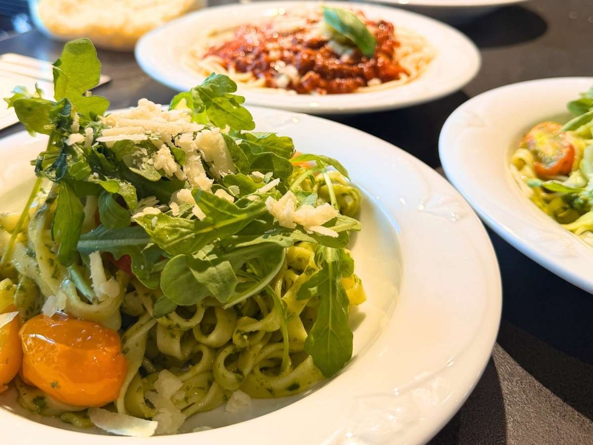 Frisch zubereitete Pasta-Gerichte mit Pesto, Rucola, Parmesan und Tomaten im Waidmanns