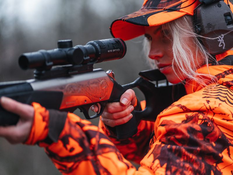 Jägerin mit Zielfernrohr bei der Drückjagd