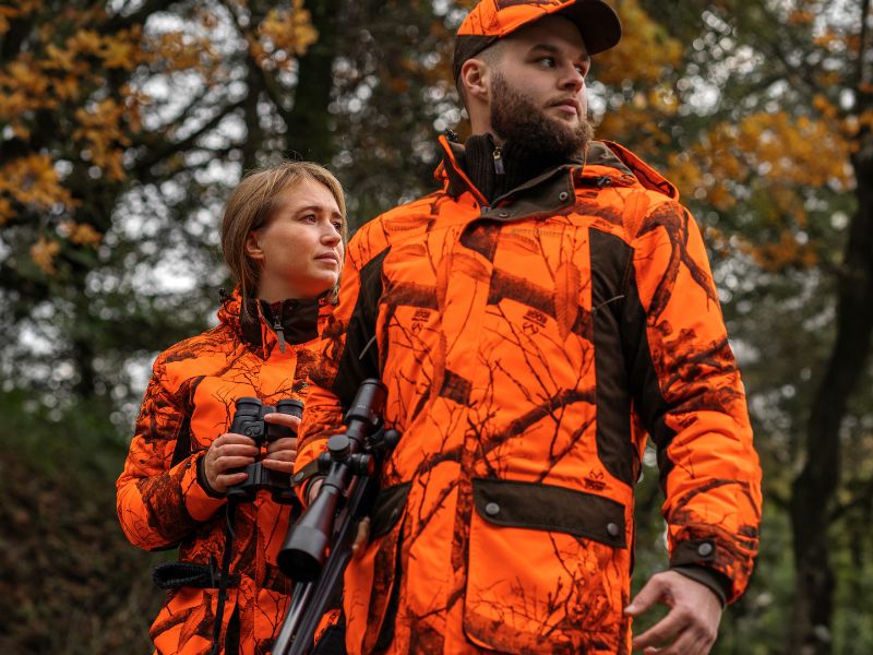 Jägerin und Jäger in signalorangen Jagdjacken