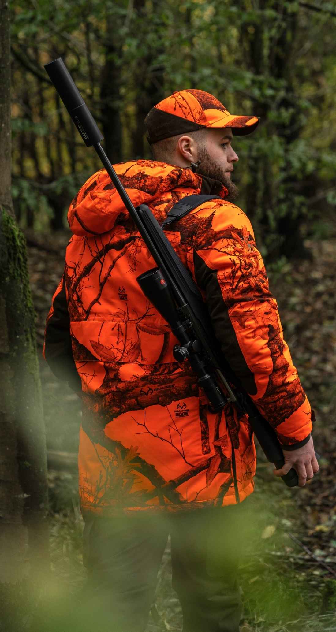 Jäger in orangefarbener Signalkleidung im Wald